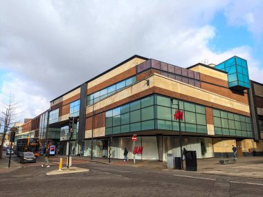 Bristol, İngiltere - 31 Ocak 2025: Yayalar, Cabot Circus adlı modern perakende binası yakınlarındaki yolun karşısına sokak köşesinde cam bir cephe ile geçtiler.