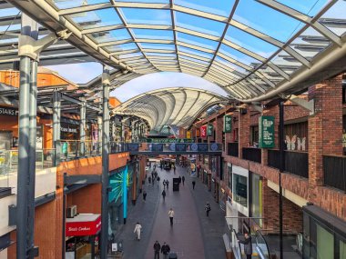 Bristol, İngiltere - 31 Ocak 2025: Müşteriler, çok katlı perakende mağazaları ve lokantalarla çevrili özel cam ve çelik çatısı altında modern Cabot Circus alışveriş merkezinde geziniyorlar