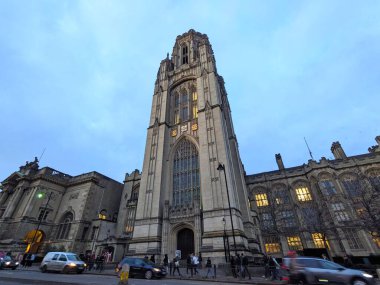 Bristol, İngiltere - 31 Ocak 2025: Bristols Üniversitesi 'nin aydınlatmalı Gotik Diriliş Kulesi' nin alacakaranlık gökyüzüne karşı şehir trafiği üzerindeki alacakaranlık manzarası