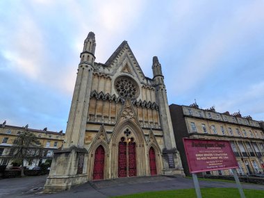 Bristol, İngiltere - 31 Ocak 2025: Buckingham Şapeli 'nin tarihi cephesi, karmaşık oymaları, kırmızı kapıları ve büyük bir gül penceresi olan çarpıcı Gotik tarzı bir kilise bulutlu bir gökyüzünün altında duruyor.