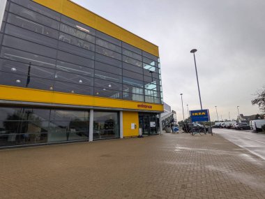 Londra, İngiltere - 16 Ekim 2021: Modern sarı cephenin dış görünüşü ve IKEA Tottenham mağaza girişinin geniş cam pencereleri asfalt bir yürüyüş yolu ve bulutlu gökyüzü