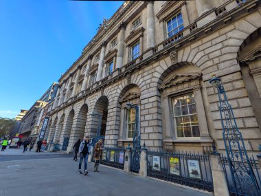 Londra, İngiltere - 05 Kasım 2021: Yayalar güneşli bir günde Somerset House 'un karmaşık giriş ve cephesinin önünden geçtiler.