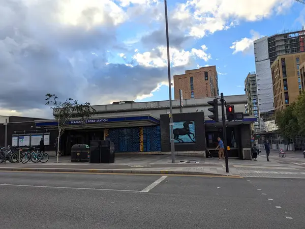 Londra, İngiltere - 25 Ekim 2021: Yaya geçitleri Blackhorse Road London Metro İstasyonu 'nun önünden geçmekte ve arkasında inşaat halindeki çağdaş bir bina ile bulutlu bir gökyüzünün altındaki bir sokak sahnesinde görünmektedir.