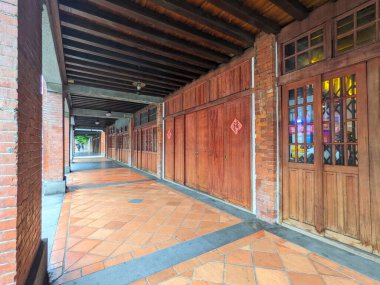 Taipei, Tayvan - 23 Kasım 2022: Bopiliao Tarihi Bloğu 'ndaki kırmızı tuğlalı sütunlar ve geleneksel ahşap mağazalarla kaplı uzun bir yürüyüş yolu başkentteki mesafeye açılıyor