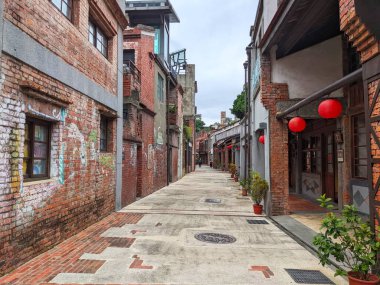 Taipei, Tayvan - 23 Kasım 2022: Bopiliao Tarihi Bloğu 'nun tarihi caddesi boyunca eski tuğla binalar ve saksı bitkileriyle kaplı geleneksel dükkanların dışında asılı duran kırmızı fenerler