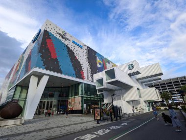 Hualien, Tayvan - 27 Kasım 2022: İnsanlar renkli bir cephe ve Starbucks 'ın çarpıcı beyaz nakliye konteynır yapılarının yer aldığı modern Vieshow Sineması ve alışveriş kompleksini ziyaret ediyor