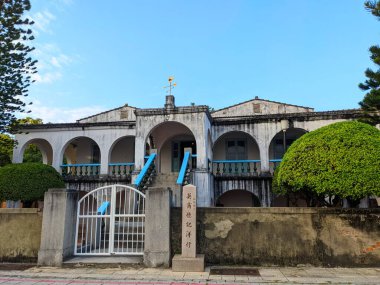 Tainan, Tayvan - 01 Aralık 2022: Tarihi Eski Tait ve Ortak Ticaret Evi, Anping 'deki eşsiz koloni kemerleri ve balkonlarıyla parlak mavi bir gökyüzünün altında duruyor.