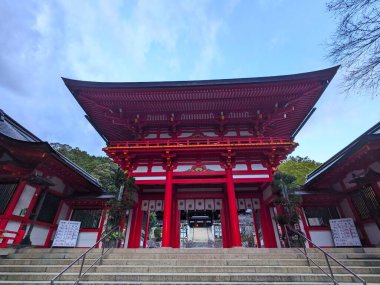 Shiga, Japonya - 20 Aralık 2023: Omi Tapınağı 'nın çarpıcı kırmızı girişi bulutlu bir gökyüzünün altında duruyor, klasik mimariyi gözler önüne seriyor ve zengin kültür mirasına şöyle bir göz atıyor: