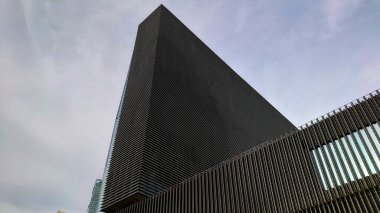 Hong Kong - 27 Ağustos 2021: Batı Kowloon Kültür Bölgesi 'nde bulutlu bir gökyüzüne uzanan modern M Plus Müzesi' nin alçak açılı görüntüsü