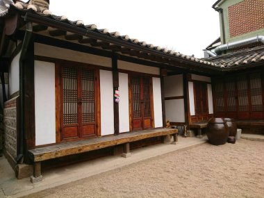 Seul, Güney Kore - Şubat 06 2019: Bukchon Hanok Villa 'da Bukchon Geleneksel Kültür Merkezi' nde ahşap kapılı pencereler ve çakıl avlusu olan geleneksel bir Kore Hanok evi