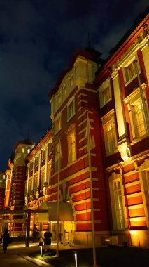 Tokyo, Japonya - 28 Ekim 2019: Tarihi Tokyo İstasyonu Marunouchi binası kırmızı tuğla cephesini ve mimari detaylarını gece aydınlatmaktadır.