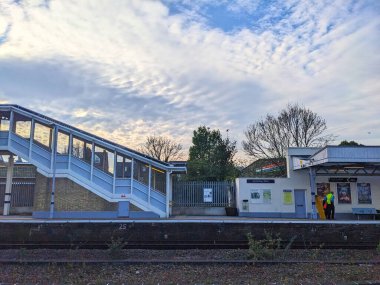 Canterbury, İngiltere - 19 Nisan 2025: Canterbury Batı tren istasyonu peronu ve merdiven manzarası bulutlu gökyüzü altında, bir kişi bekleme alanının yanında duruyor