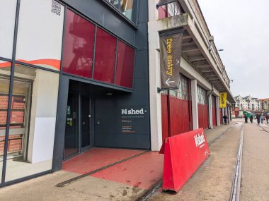 Bristol, İngiltere - 29 Ocak 2025: Yayalar bulutlu bir gökyüzünün altında yer alan liman cephesi boyunca yer alan Bristols tarihi ve yaşamını ayrıntılı olarak anlatan bir kültür kurumu olan M Shed Müzesi 'nin önünden geçtiler