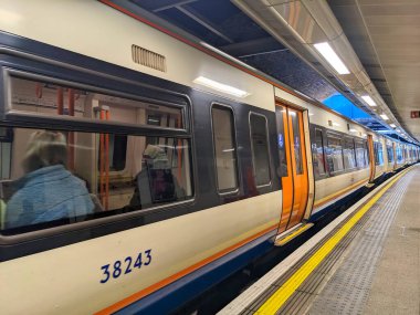 Londra, İngiltere - 07 Mart 2023: Modern bir Londra Overground treni Windrush Hattı 'nın iyi ışıklandırılmış Rotherhithe istasyonunda durduruldu.
