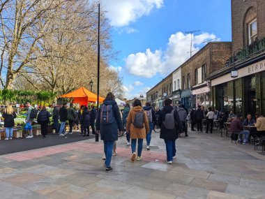 Londra, İngiltere - Nisan 03 2022: Parlak bir hafta sonunda parçalı bulutlu bir gökyüzü altında, Columbia Road Flower Market 'te büyük bir kalabalık yürür ve tezgahlarda dolaşır.