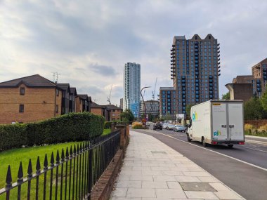 Londra, İngiltere - 20 Eylül 2021: Forest Road View, bulutlu bir gökyüzü altında yol boyunca yol alan beyaz bir dağıtım minibüsü ve araçlarla konut evleri ve yüksek katlı apartmanların bir karışımını gösteriyor
