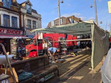 Londra, İngiltere - 21 Eylül 2021: Londra 'da canlı bir Walthamstow High Street pazarı gelişiyor, yerel satıcılar tezgahlarında mal paketlerken müşteriler açık mavi gökyüzü altında geziniyorlar