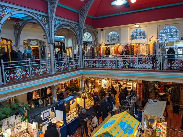 Londra, İngiltere - 27 Kasım 2021: Alışverişçiler, Londra 'nın el sanatları, giysiler ve benzersiz hediyeler için popüler bir tatil yeri olan tarihi Camden Pazarı' nın hareketli Viktorya dönemi mimarisinde hareketli tezgahlara göz atıyorlar