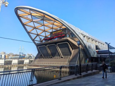 Londra, İngiltere - 11 Mayıs 2025: Foster Partners tarafından tasarlanan Canary Wharf Crossrail Place 'in çarpıcı kereste kafes çatısı, modern finans bölgesinde rıhtımın üzerinde duruyor.