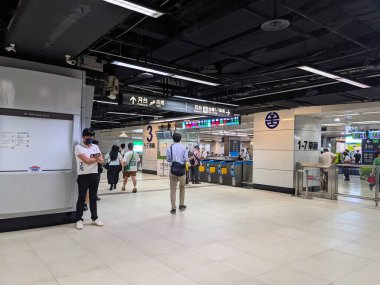 Taipei, Tayvan - 23 Mayıs 2025: Yolcular, yoğun bir ulaşım merkezindeki HSR yüksek hızlı tren ve TRA tren platformlarına giden modern tabelalar ve bilet kapılarıyla ana salondan geçecekler