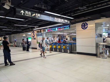 Taipei, Tayvan - 23 Mayıs 2025: Bagajlı yolcular, işlek bir modern ulaşım merkezi olan Taipei Ana İstasyonu 'ndaki TRA platformlarına giden elektronik bilet kapısından geçtiler