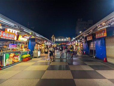 Hualien, Tayvan - 23 Mayıs 2025: İnsanlar Dongdamen Gece Pazarı 'nda gezip aydınlatılmış gıda tezgahlarını keşfediyor ve çeşitli geleneksel Tayvan sokak atıştırmalıkları satıyor.
