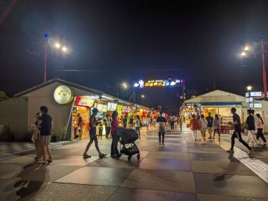 Hualien, Tayvan - 23 Mayıs 2025: Canlı bir kalabalık ünlü Dongdamen Gece Pazarı 'nı geziyor, otantik yerel Tayvan sokak yemekleri sunan parlak ışıklı gıda tezgahlarının önünden geçiyor