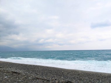 Hualien, Tayvan - 25 Mayıs 2025 Pasifik Okyanusu 'ndan gelen dalgalar Qixingtan' ın manzaralı sahil şeridi boyunca uzanan engebeli bir çakıl taşına çarpar.