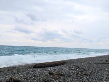 Hualien, Tayvan - 25 Mayıs 2025: Pasifik Okyanusu 'ndan gelen dalgalar Qixingtan' daki bir çakıl taşlı plajda karamsar, bulutlu bir gökyüzü altında dağınık dalgalanıyor