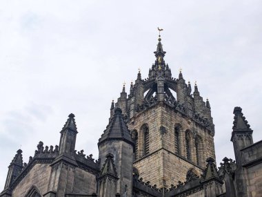 Edinburgh, İngiltere - 17 Temmuz 2025: Aziz Giles Katedrali 'nin karmaşık Gotik taç çan kulesinin alçak açılı görüntüsü, Eski Kentteki Royal Mile' ın tarihi bir simgesi bulutlu bir gökyüzüne karşı