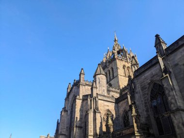 Edinburgh, İskoçya - 16 Temmuz 2025: Düşük açı St. Giles Katedrali 'nin karmaşık Gotik taş işçiliğini ve Crown Çan Çanı' nı açık bir yaz gökyüzüne karşı çeker