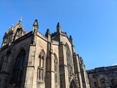 Edinburgh, İskoçya - 16 Temmuz 2025: Düşük açı St. Giles Katedralleri 'nin detaylı mimarisini yakalar ve parlak mavi gökyüzüne karşı ilham verir