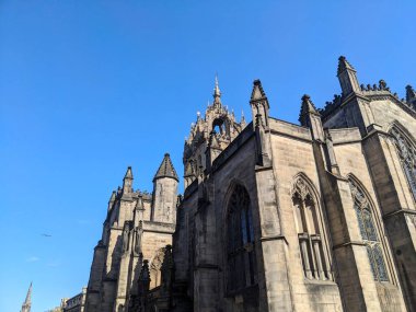 Edinburgh, İskoçya - 16 Temmuz 2025: Tarihi St. Giles Katedrali 'nin alçak açılı görüntüsü, Royal Mile' daki Gotik mimarinin güzel bir örneği, ikonik Crown Çan kulesiyle berrak bir gökyüzüne karşı