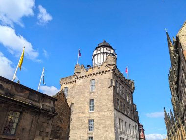 Edinburgh, İskoçya, İngiltere - 18 Temmuz 2025: Açık mavi gökyüzü altında The Hub 'un Gotik kulelerinin yanındaki tarihi Obscura ve Outlook Kulesi' nin alçak açılı görüntüsü