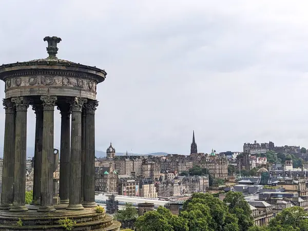 Edinburgh, İskoçya - 15 Temmuz 2025: Calton Hill 'deki ikonik Dugald Stewart Anıtı' ndan kaleyi de içeren tarihi şehir siluetinin panoramik bir görüntüsü