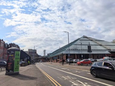 Glasgow, İskoçya - 14 Temmuz 2025: Stockwell Caddesi 'nden St. Enoch Alışveriş Merkezi' nin ikonik cam çatı manzarası, dinamik ve bulutlu bir gökyüzü altında şehir trafiği