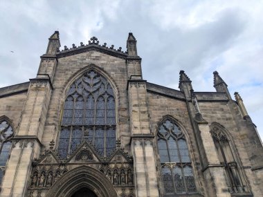 Edinburgh, İskoçya - 17 Temmuz 2025: Düşük açılı bir perspektif, bulutlu bir gökyüzü altında Kraliyet Mil 'inin ünlü bir simgesi olan tarihi St. Giles Katedrali' nin karmaşık Gotik cephesini yakalar