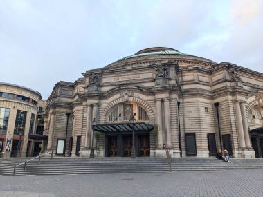 Edinburgh, İskoçya - 15 Temmuz 2025: Şehir merkezinde ünlü bir konser salonu olan Usher Salonu 'nun tarihi Beaux-Arts cephesi, insanların bulutlu bir gökyüzü altında büyük merdivenlerde oturduğu
