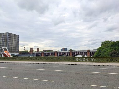 Glasgow, İngiltere - 14 Temmuz 2025: Tarihi Viktorya Birliği Demiryolu Köprüsü, veya St Enoch Köprüsü, Clyde Nehri üzerinde, modern mimarisi ve Glasgow Merkez Camii ile bulutlu bir gökyüzü altında görünür.