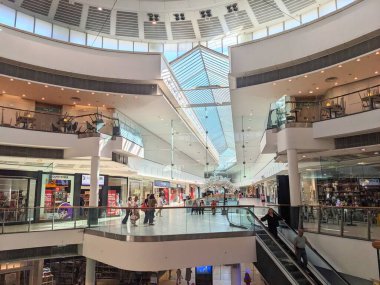 Glasgow, İngiltere - 12 Temmuz 2025: Müşteriler mağazalara göz atıyor ve modern, çok katlı Buchanan Galerileri alışveriş merkezinin gözde cam çatısı olan çok katlı iç kısımlarında yürüyen merdivenleri kullanıyorlar