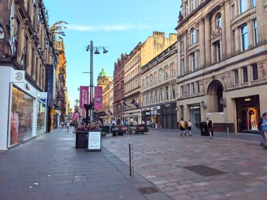Glasgow, İngiltere - 12 Temmuz 2025: Yayalar, tarihi mimarisi ve 850. yıldönümünü kutlayan afişlerle dolu popüler bir alışveriş alanı olan Buchanan Caddesi boyunca yürüyor
