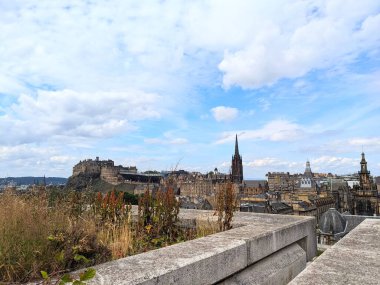 Edinburgh, İngiltere - 17 Temmuz 2025: Tarihi şehir manzarası, ikonik kale ve Eski Şehir kuleleri de dahil olmak üzere parçalı bulutlu bir gökyüzü altında yer alır.
