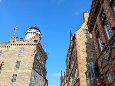 Edinburgh, İngiltere - 18 Temmuz 2025: Düşük açı perspektifi, yazları bulutsuz ve parlak mavi gökyüzüne karşı hazırlanan tarihi Royal Mile 'ın detaylı ortaçağ ve Gotik mimarisini yakalar