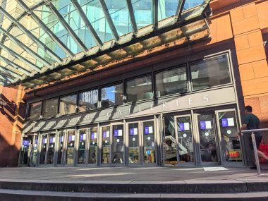 Glasgow, İskoçya - 12 Temmuz 2025: Büyük bir şehir merkezi alışveriş merkezi olan Buchanan Galerileri 'nin modern girişi, güneş ışığının cam ve taş cephesine yansıyan gölgeleriyle