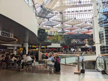 Glasgow, İngiltere - 14 Temmuz 2025: St. Enoch Merkezi 'nin popüler ve modern alışveriş merkezi olan yoğun, çok katlı yemek katında insanlar yemek yiyor ve sosyalleşiyor