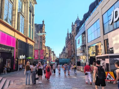 Glasgow, İngiltere - 12 Temmuz 2025: Günes isigi, yayaya çikmis Buchanan Caddesi boyunca gezen büyük bir kalabalik, modern ve tarihi mimarinin bir karisiminin yer aldigi büyük bir perakende merkezidir.