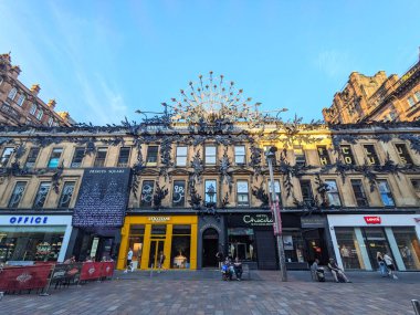 Glasgow, İngiltere - 12 Temmuz 2025: Princes Square alışveriş merkezinin çarpıcı Viktorya dönemi cephesi, lüks bir perakende satış merkezi, müşteriler açık bir gökyüzü altında Buchanan Caddesi 'nde yayalar halinde geziniyor