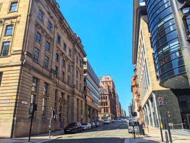 Glasgow, İngiltere - 12 Temmuz 2025: Güneşli bir Wellington Caddesi manzarası, tarihi kumtaşı cepheleriyle çağdaş cam ofis binaları arasındaki zıtlığı gözler önüne seriyor