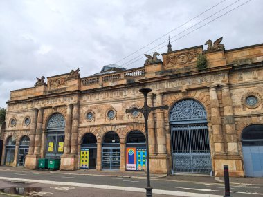 Glasgow, İskoçya - 14 Temmuz 2025: Tarihi Briggait binasının süslü taş cephesi, şimdi yaratıcı bir merkez olan eski bir balık pazarı, şehir merkezinde bulutlu bir gökyüzünün altında duruyor.