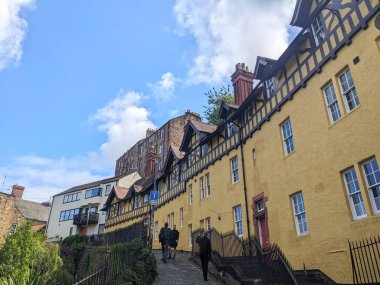 Edinburgh, İngiltere - 16 Temmuz 2025: Turistler Hawthornbank Lane 'in dik patikasında, geleneksel ahşap çerçeveli mimariye hayran kalarak yürüyorlar.